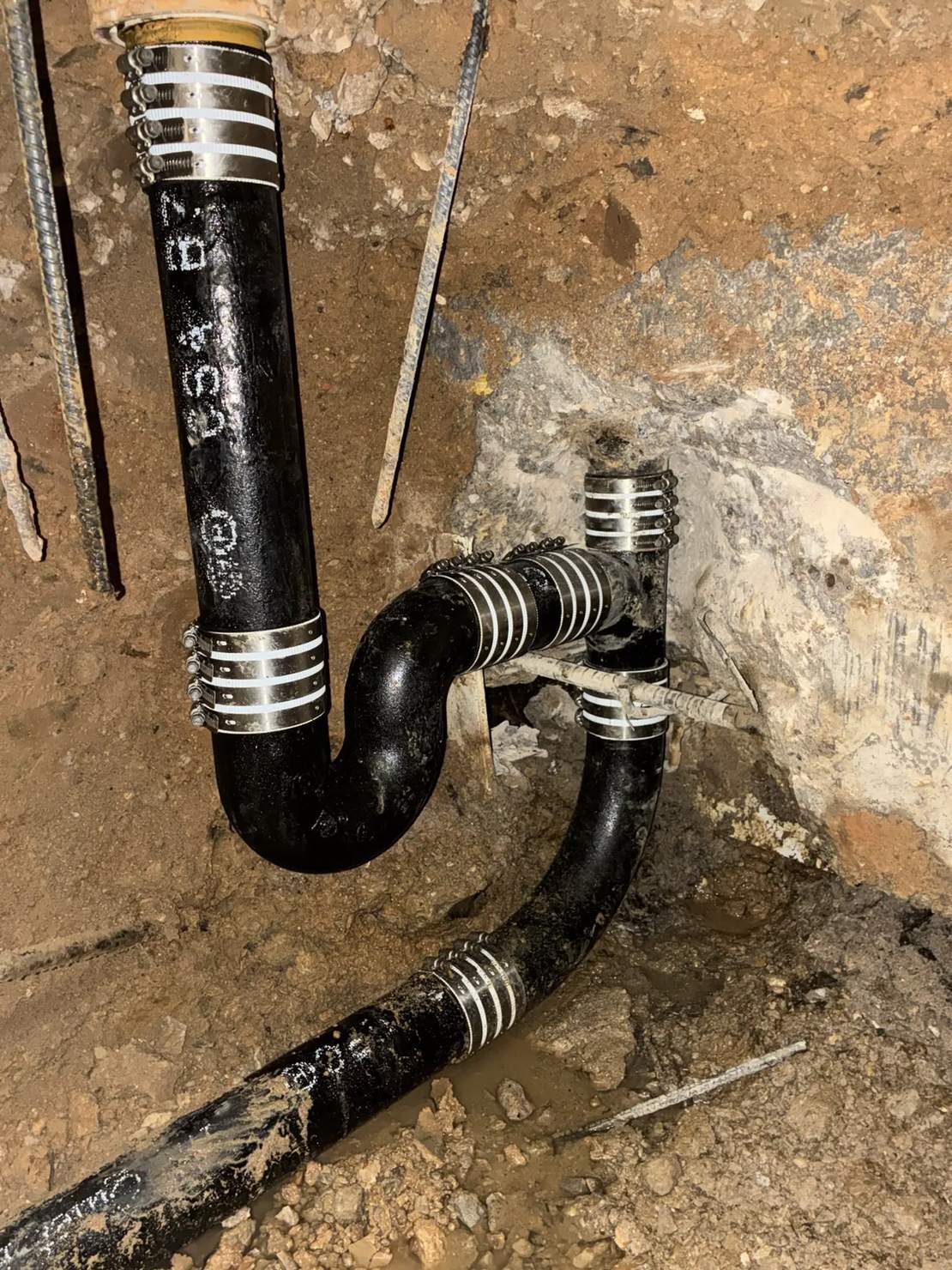 Cast iron drain and trap under a slab joined with heavy-duty stainless no-hub couplings