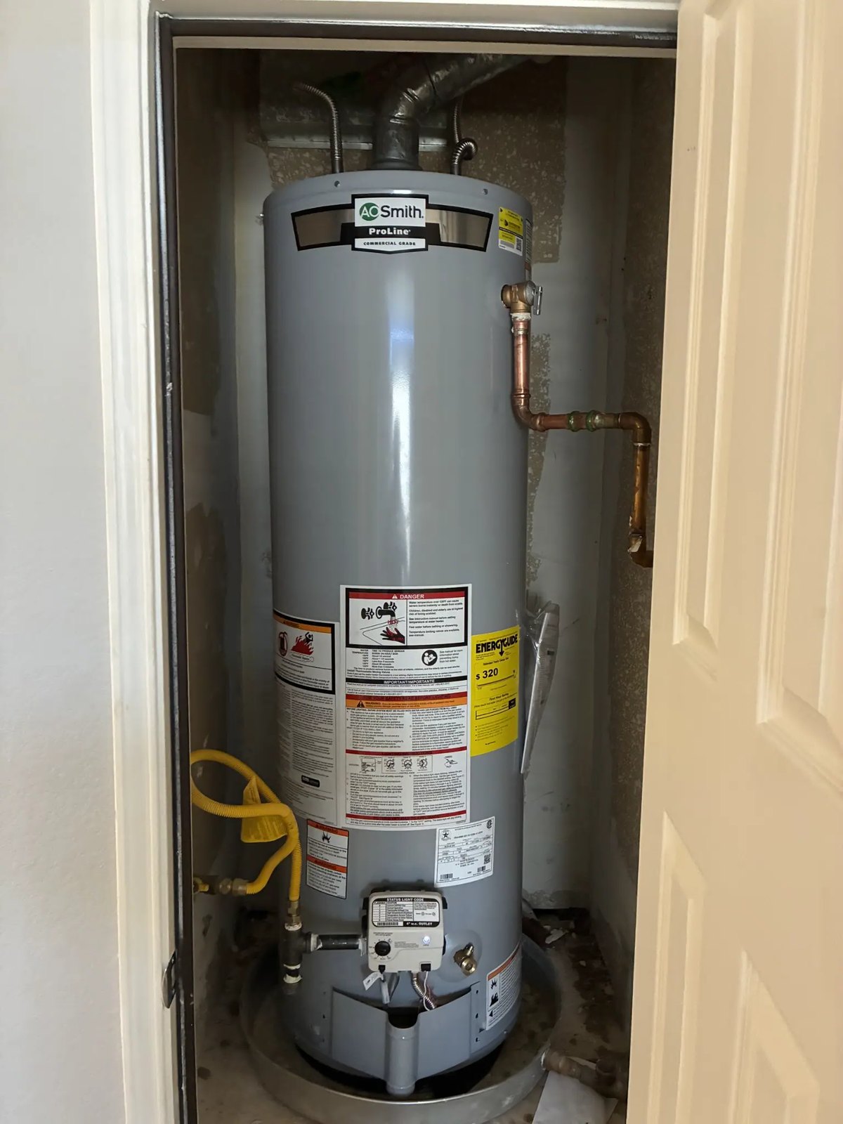 New gas water heater installed in a closet in Allen, TX, with sediment trap, drain pan, and relief line