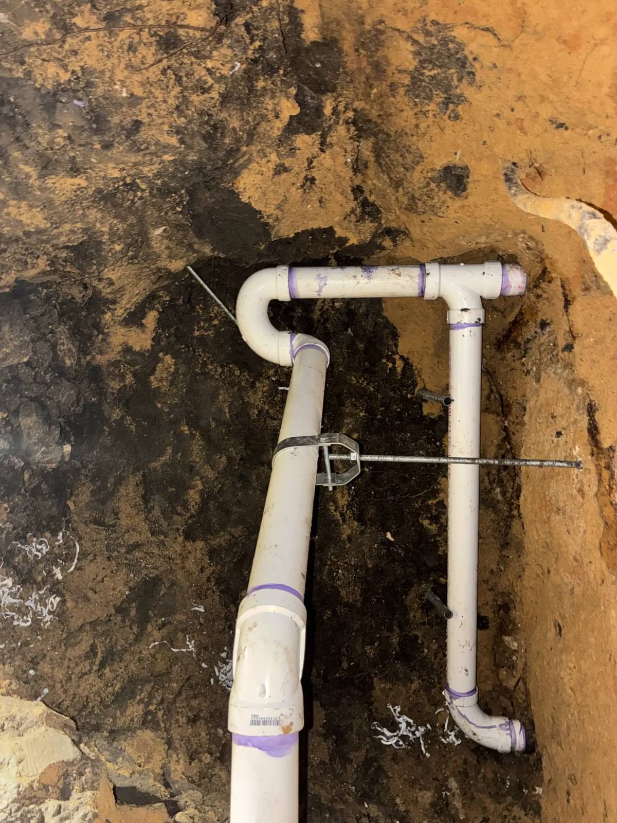 New PVC drain and trap installed in a tunnel under a slab foundation